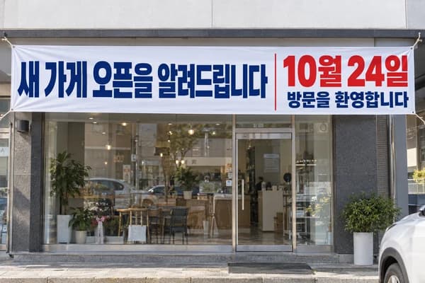 개업 현수막 활용 예시 — 매장 전면의 긴 벽 (500×90cm)